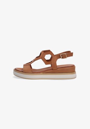 Leder-Sandale in Tan mit hexagonalem Ausschnitten, verstellbarem Knöchelriemen und einer geschichteten weißen Sohle für Dämpfung und Unterstützung.