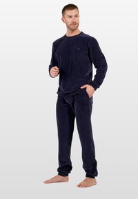 Conjunto de ropa de estar por casa en color azul marino de pana, que incluye una camiseta de manga larga y pantalones a juego con textura acanalada y puños elásticos.