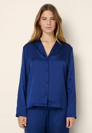 Navy satijnen pyjama-top met een gelapte kraag, lange mouwen, knoopsluiting en een comfortabele pasvorm. Soepele textuur met een glanzende afwerking.