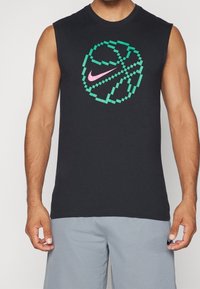 T-shirt noir sans manches avec un graphique de basketball pixélisé en vert et rose. Tissu en coton doux avec un col rond.