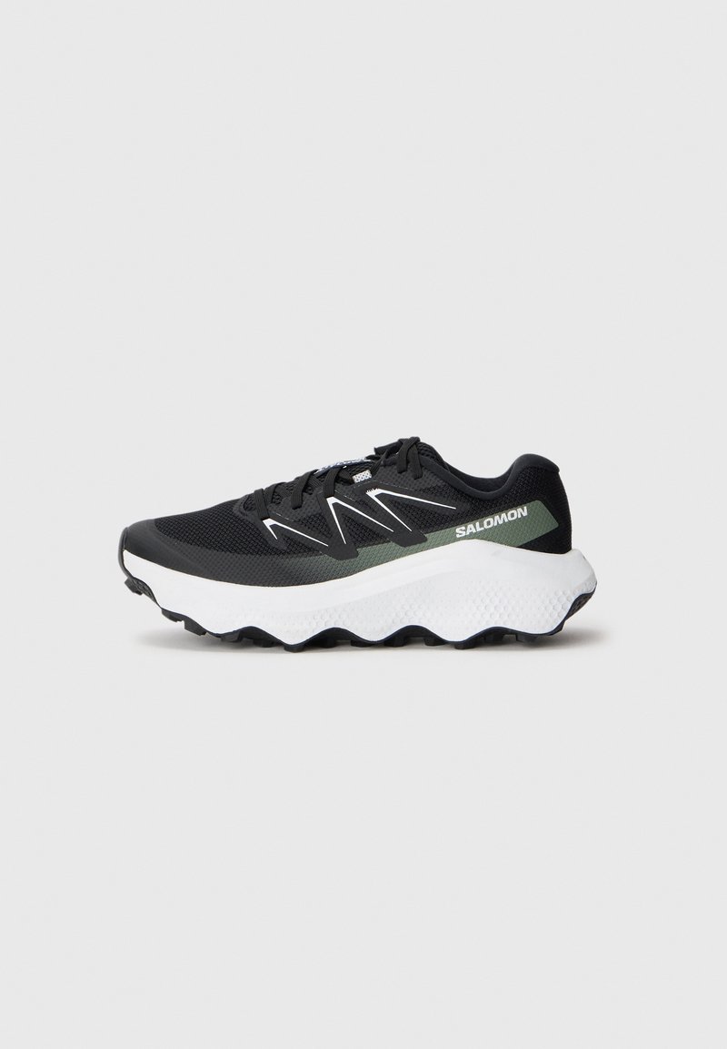 Baskets de sport noires avec un supérieurs en mesh, des accents blancs et vert clair, une semelle blanche rembourrée et une adhérence texturée sur la semelle extérieure.