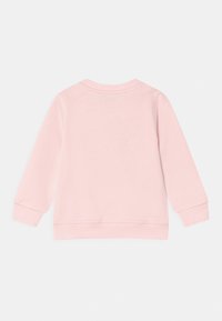Sudadera de color rosa claro con mangas largas, puños acanalados y cuello redondo. Tejido suave con una textura lisa y sin patrones visibles.