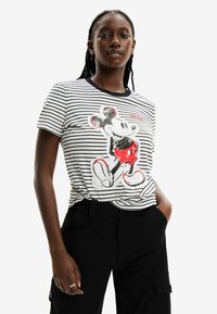 Camiseta de algodón con rayas que presenta un gráfico de un personaje en rojo y negro. La camiseta tiene mangas cortas y un escote redondo con un borde oscuro.