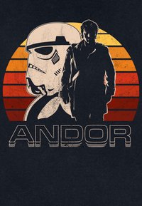 Figura in silhouette in piedi davanti a un grande casco da Stormtrooper con uno sfondo a cerchio retro arancione e rosso a strisce, etichettato "ANDOR."