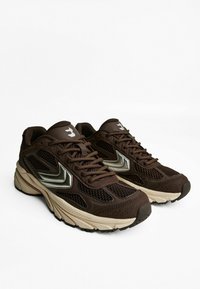 Braune Sportschuhe mit einem Obermaterial aus Netzgewebe, reflektierenden Akzenten und einer strukturierten Sohle. Schnürsenkel in passendem Braun. Ferse in Beige.