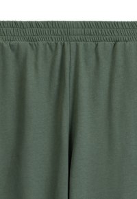 Zielone dresy wykonane z mieszanki bawełny mają elastyczny pasek w talii, gładką strukturę oraz luźny krój z prostymi nogawkami, co czyni je idealnymi dla wygody.