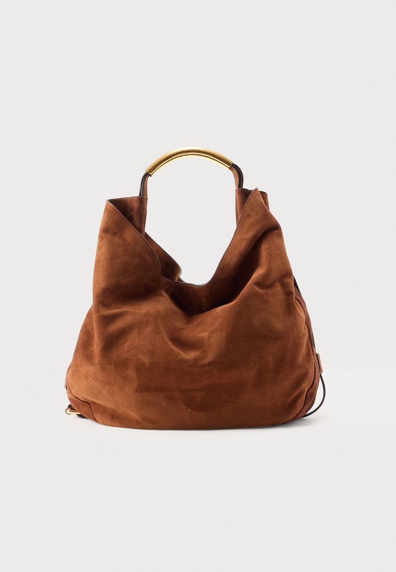 Καφέ τσάντα ώμου από σουέτ με χαλαρή μορφή και κοντή λαβή από μέταλλο με χρυσή απόχρωση σε λευκό φόντο.