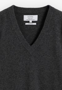 Suéter gris de lana con cuello en V. Textura suave, cuello acanalado y etiqueta adjunta. La etiqueta indica talla S y lana italiana.