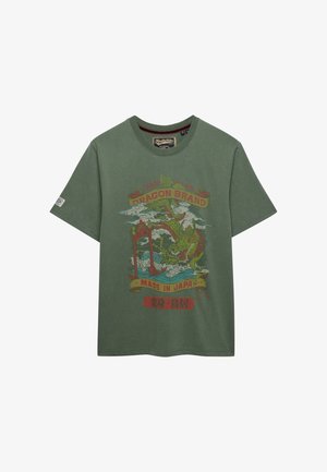 Maglietta verde a maniche corte con un'illustrazione colorata di un drago, onde giapponesi e testo "Dragon Brand" e "Made in Japan" sul davanti.