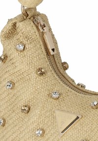 Beige geweven strooien tas met een ritssluiting, versierd met gouden en heldere rhinestones. Heeft een driehoekig logo in goudmetaal.