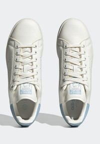Vita lädersneakers med en slät yta, prydda med perforeringar, ljusblå detaljer och platta skosnören. Strukturerad gummisula.