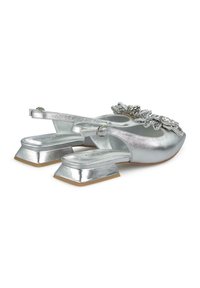 Scarpe slingback argentate con finitura metallica, tacco quadrato e decorazioni floreali sulla zona delle punte.