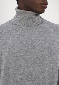 Grijze turtleneck trui van zachte, gestructureerde stof, met een geribbelde kraag en een naadloos ontwerp, geschikt voor casual draagbaar.
