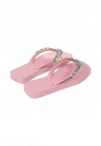 Roze flip-flops met een gestructureerde binnenzool. De bandjes zijn versierd met meerkleurige juwelen en een glanzende accent, wat een decoratief detail aan het ontwerp toevoegt.
