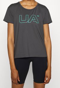 Grå kortärmad t-shirt i mjukt tyg med en teal- och rosa "UA"-logotyp på framsidan. Matchas med svarta shorts.