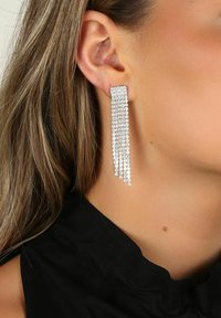 Långa silverörhängen med flera rader av gnistrande rhinestones, kaskadformat i en lagerdesign, med en smal rektangulär överdel.