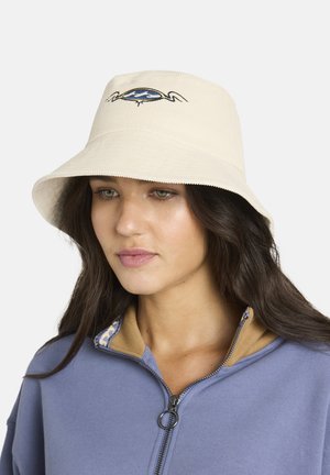 Sombrero tipo bucket de algodón en color crema con ala ancha y bordado de cangrejo azul en la parte frontal. Acompañado de una sudadera azul con detalle de cremallera en el cuello.