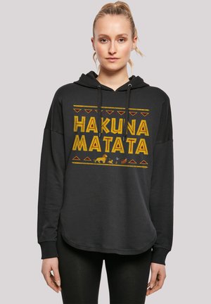 Schwarzer Kapuzenpullover mit abgerundetem Saum, der "HAKUNA MATATA" in gelbem Text zeigt, akzentuiert durch rote und gelbe geometrische Muster sowie Tier-Silhouetten.