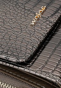 Portafoglio in pelle grigia con motivo coccodrillo e dettagli in oro. Presenta una superficie liscia, una chiusura a zip e accenti di cucitura.