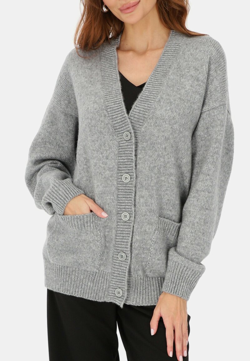 Szary dziergany kardigan z dekoltem w serek, z zapięciem na guziki, ściągaczami na mankietach oraz dwiema przednimi kieszeniami. Miękka tekstura i luźny krój.