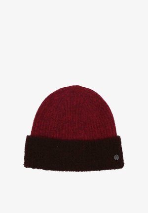 Beanie rosso lavorato a maglia con orlo piegato marrone scuro e un piccolo emblema metallico rotondo sul lato destro inferiore dell'orlo.