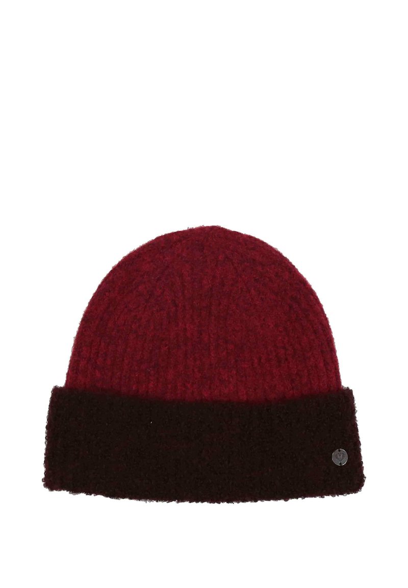 Red knitted beanie with dark brown folded brim and a small round metal emblem on the brim’s lower right side.