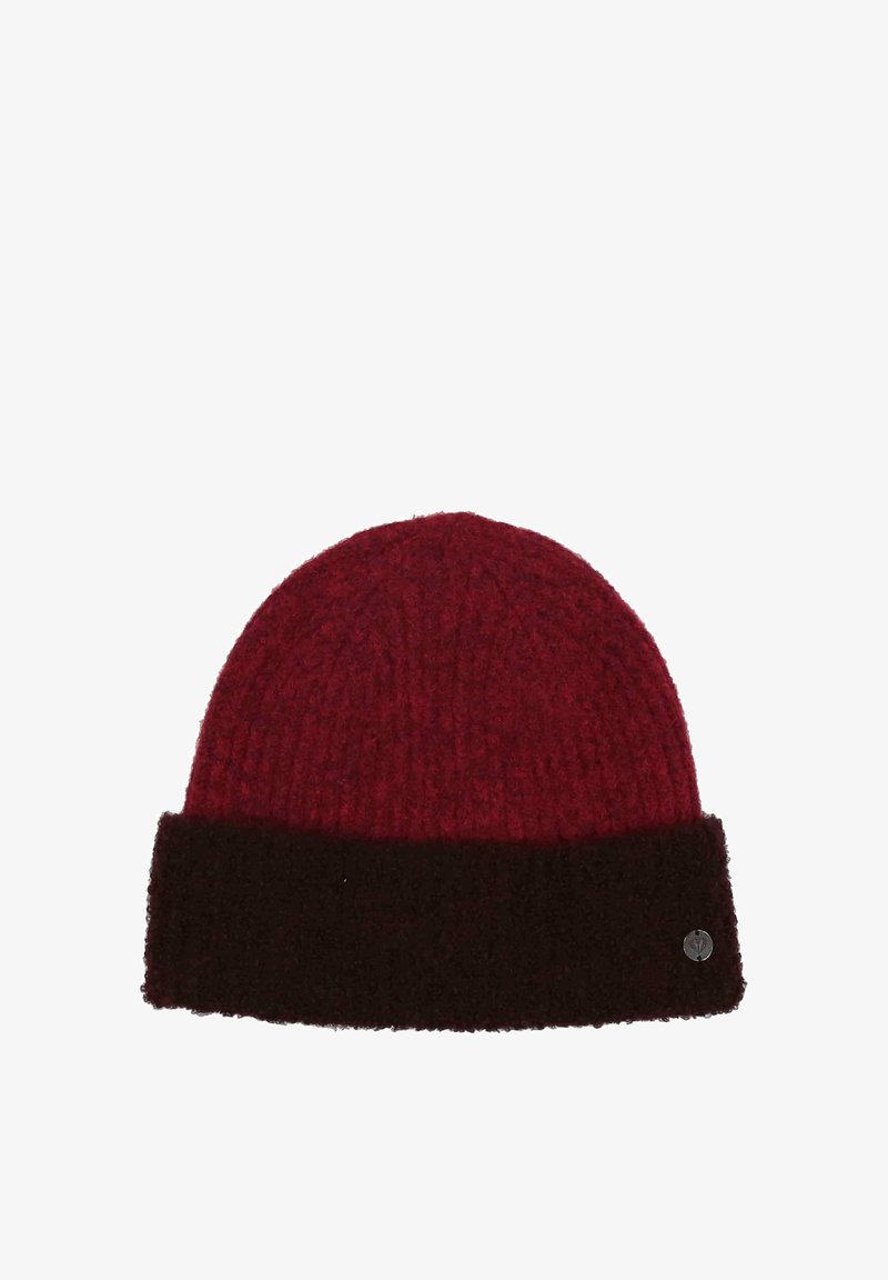 Beanie rosso lavorato a maglia con orlo piegato marrone scuro e un piccolo emblema metallico rotondo sul lato destro inferiore dell'orlo.