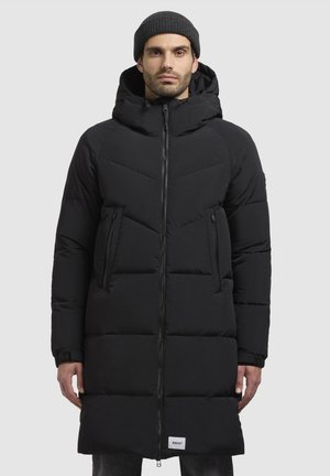 Black padded long coat with a hood, zip closure, two front pockets, and a quilted texture. Brand logo visible at the hem.