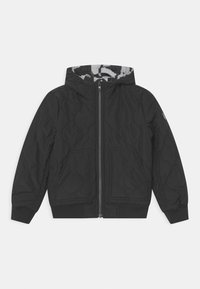 Chaqueta negra acolchada con capucha, cremallera frontal, dos bolsillos frontales y puños y dobladillo de canalé, dispuesta plana sobre un fondo blanco.