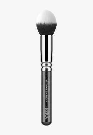 Pennello da trucco con una testa arrotondata e setole morbide in bianco e nero, e un ferretto di metallo argentato. Il manico è elegante e nero con dettagli di branding.