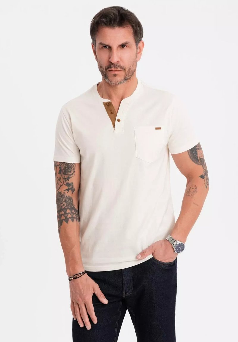 Kortærmet henley skjorte i off-white bomuld med en brun knapstolpe, brystlomme og et lille accentmærke. Glat tekstur.