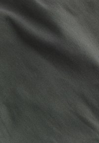 Texturiertes dunkelgraues Gewebe mit einer glatten Oberfläche, das ein feines Gewebemuster und einen leichten Glanz aufweist, hauptsächlich in einer einheitlichen Farbe.