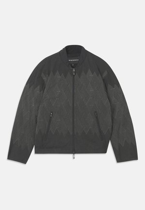 Black bomber jacket featuring a geometric pattern, zip closure, side pockets, and a ribbed collar. Made from a textured, durable material.