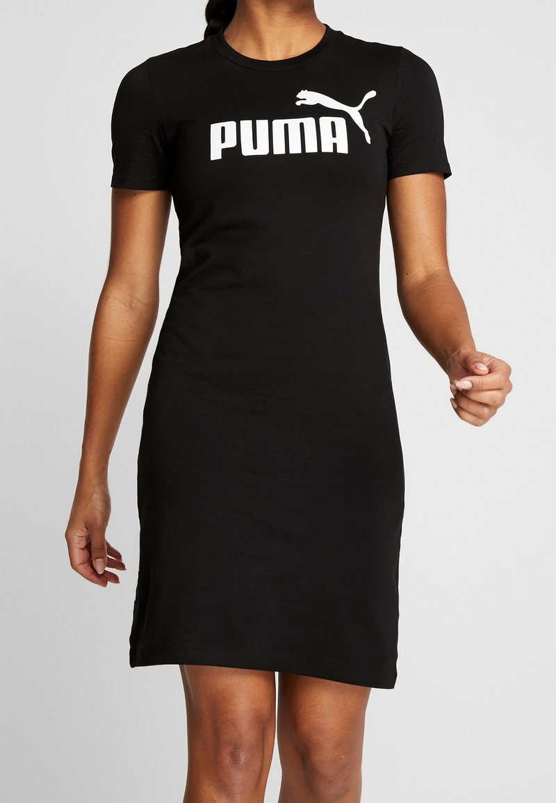 Robe t-shirt en coton noir à manches courtes, avec un grand logo "PUMA" blanc et un graphique de puma sautant sur la poitrine. Texture lisse.