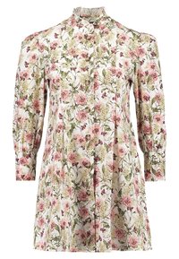 Chemise à boutons à motif floral avec manches longues bouffantes, présentant des motifs de fleurs roses et vertes sur un fond blanc et un col montant.