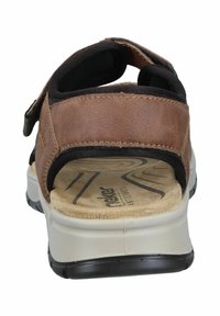 Brown leather sandal with black fabric straps, cushioned insole, and rubber outsole. Features adjustable velcro closure and textured detailing.