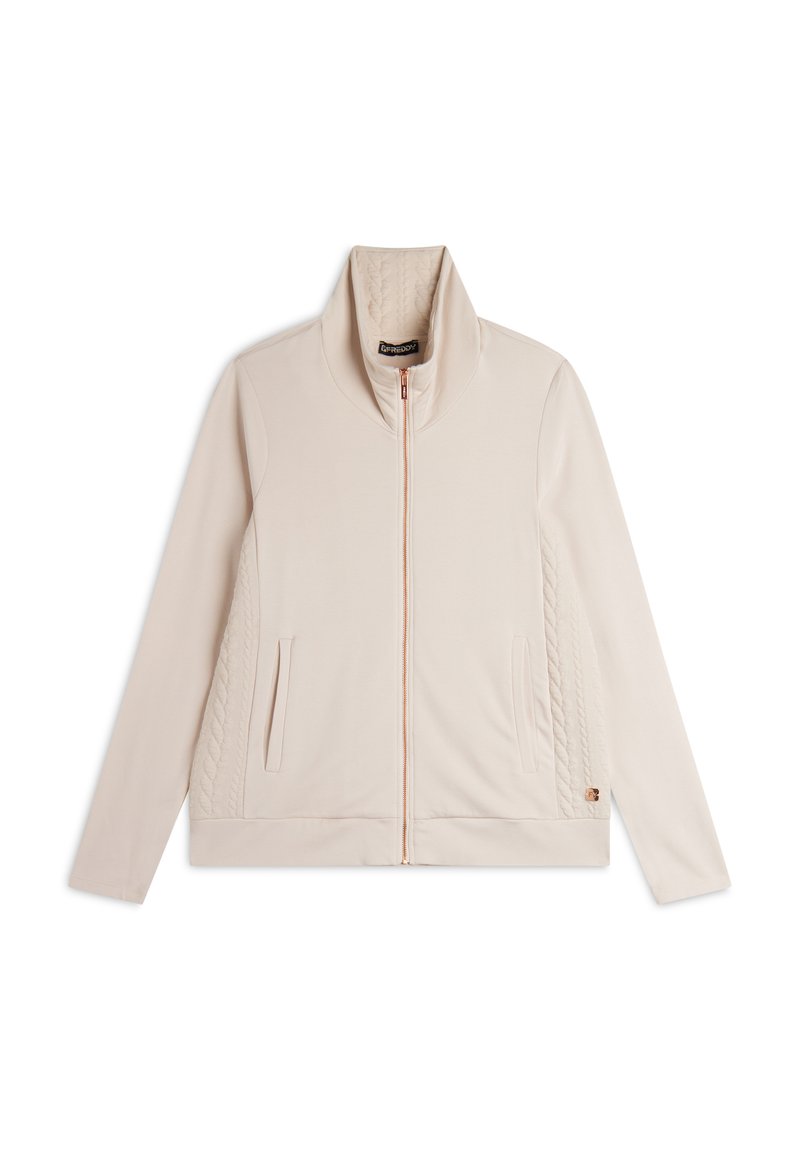 Giacca zip-up color beige chiaro con colletto alto, dotata di pannelli laterali trapuntati, due tasche frontali e un logo discreto sul bordo.