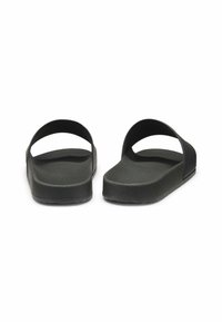 Pantofole nere con suola in tessuto, piattaforma elevata e due cinturini curvi nella parte superiore. Finitura liscia con dettagli sottili.