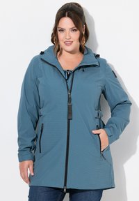 Chaqueta impermeable azul con cremallera frontal, capucha ajustable con cordón, bolsillos laterales y cintura fruncida para un ajuste a medida.