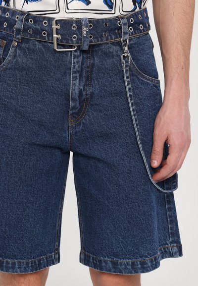 Scurți din denim cu o nuanță albastră, având un talie cu curea și gauri, buzunare frontale și un detaliu de buclă pe lateral pentru un plus de versatilitate.