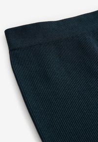 Tessuto nero a costine con una fascia elastica testurizzata, caratterizzato da sottili righe verticali. Il bordo è rifinito in modo liscio senza ulteriori dettagli.