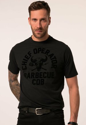 Schwarzes T-Shirt mit großem Grafikdruck eines Stier-Schädels und dem Text "CHIEF OPERATOR BARBECUE COB." Kurze Ärmel und Rundhalsausschnitt.
