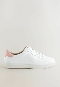 Baskets blanches basses avec lacets blancs et empiècements en daim rose au talon et sur la languette, présentées sur un fond neutre.