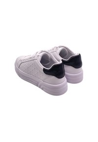 Sneaker bianco con pannelli laterali testurizzati e accentuazione nera sul tallone. Presenta una finitura liscia, punta rotonda e suola in gomma resistente. Dettaglio dei lacci visibile.