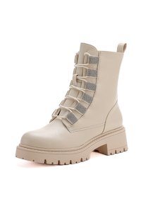 Botte de combat beige mi-mollet avec semelle épaisse, sangles élastiques décoratives ornées de strass et tirette à l'arrière.