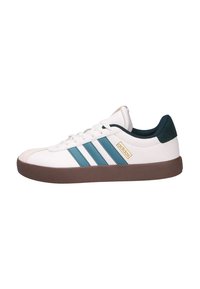 Zapatillas blancas con rayas en azul verdoso, suela de goma marrón y parte superior texturizada. Presenta un logo dorado y un acento en verde oscuro en el talón.