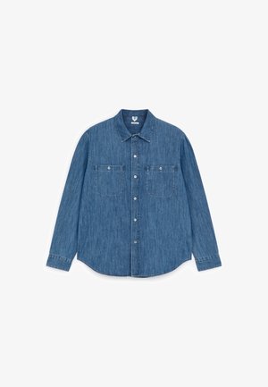 Langærmet blå denimskjorte med to knappede brystlommer foran og en krave med knapper, lagt fladt på en hvid baggrund.