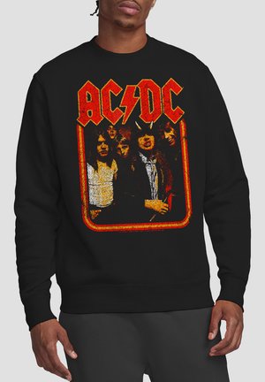Black sweatshirt featuring a retro AC/DC graphic with bold yellow and red lettering. Soft texture, classic crew neckline, and ribbed cuffs.