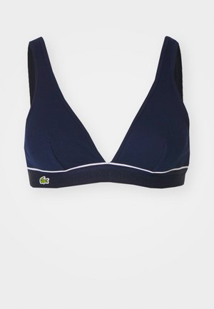 Mornarska triangularna bralette iz rebraste tkanine, z belim robom in kontrastnim pasom z embosiranim logotipom "LACOSTE" in zelenim krokodilom.