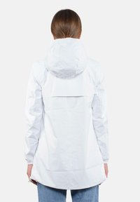 Giacca impermeabile bianca con cappuccio, apertura posteriore e polsini elastici, realizzata in materiale leggero e morbido. La lunghezza supera i fianchi.